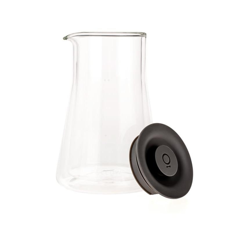 A clear glass carafe with a black lid and spout, designed for use with a coffee dripper.